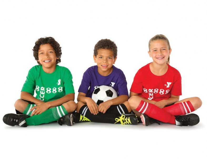 Three children wearing soccer attire with a soccer ball